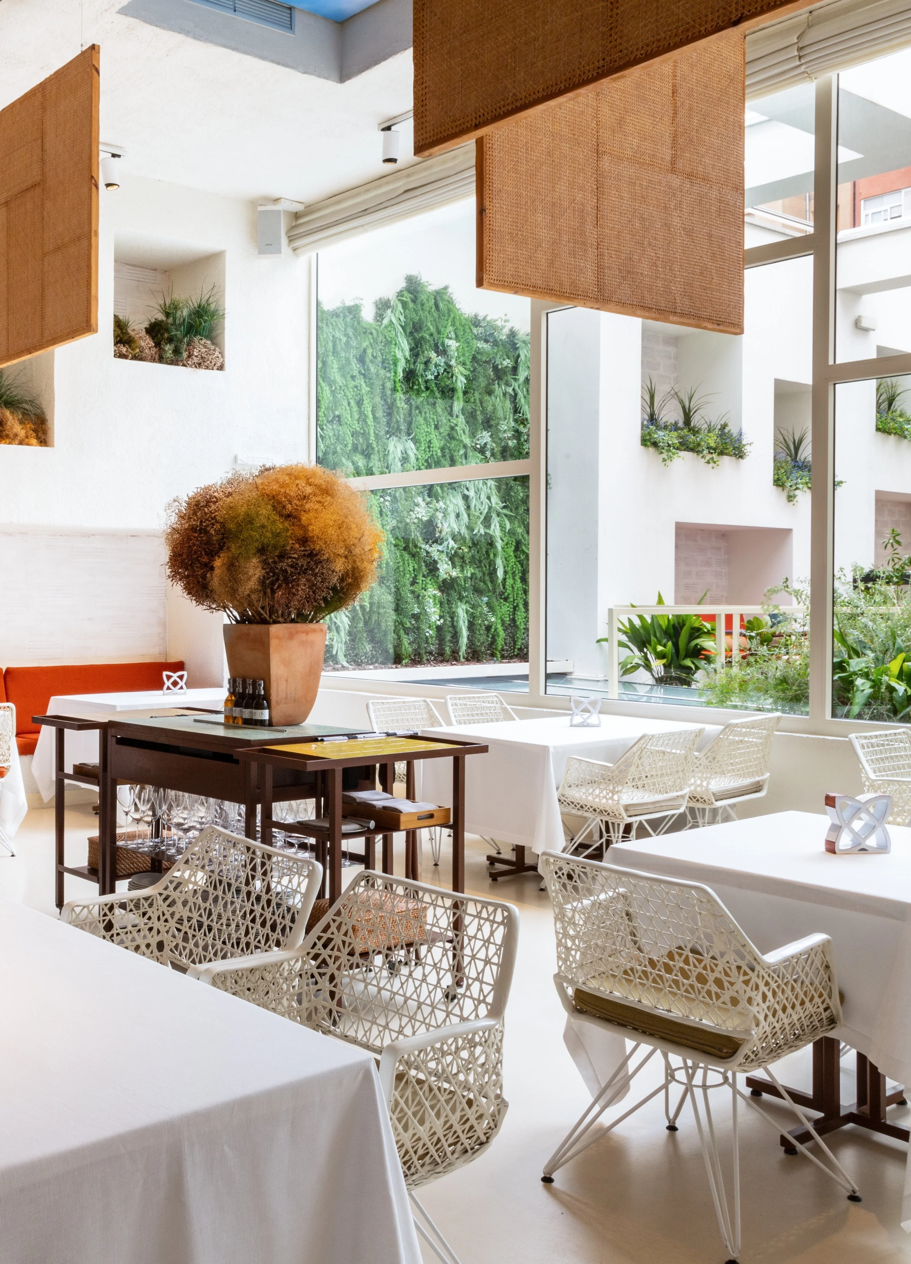Disfrutar’s bright dining room with white tables and views of the terrace
